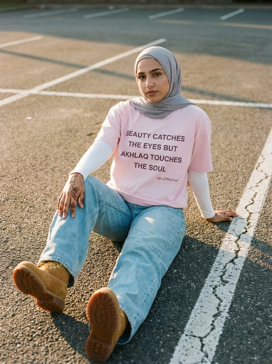 Soft pink Akhlaq Over Beauty tee layered over a white long sleeve