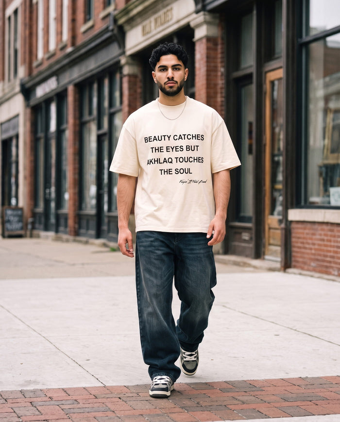 Akhlaq Over Beauty natural boxy tee walking a shopfront street