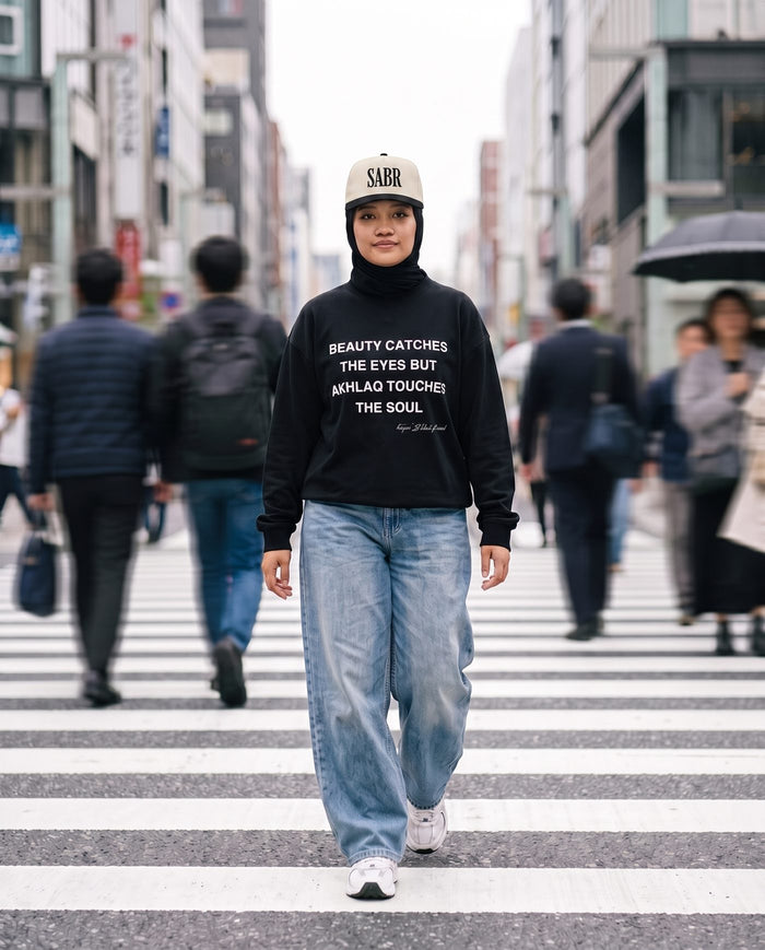 Akhlaq Over Beauty black long sleeve at a busy crosswalk