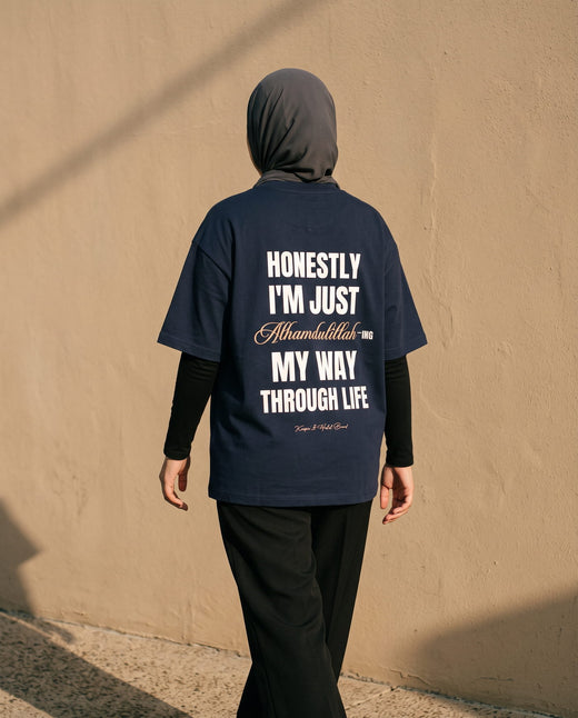 Honestly, Alhamdulillah navy boxy tee back print walking past an adobe wall