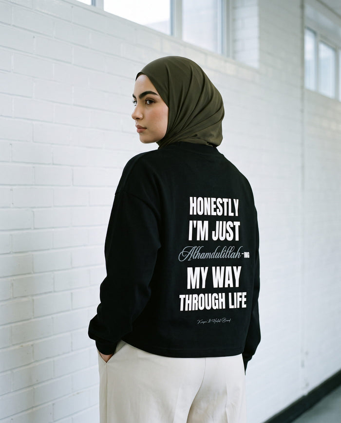 Honestly, Alhamdulillah black long sleeve back print against white brick