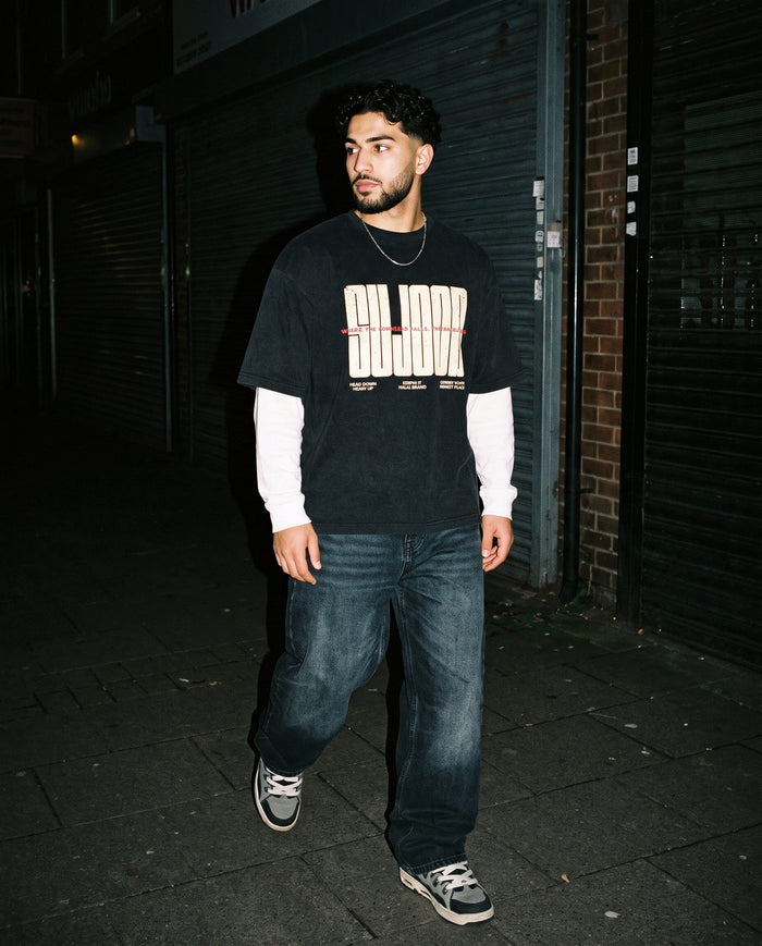 Sujood for the Heart black boxy tee walking at night