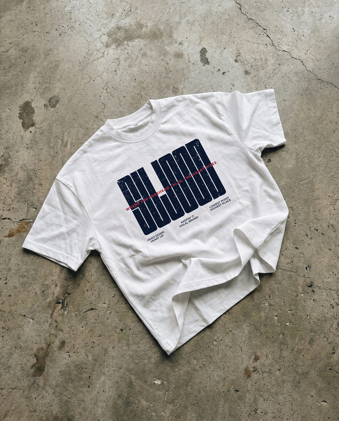 Sujood for the Heart white boxy tee laid flat on concrete