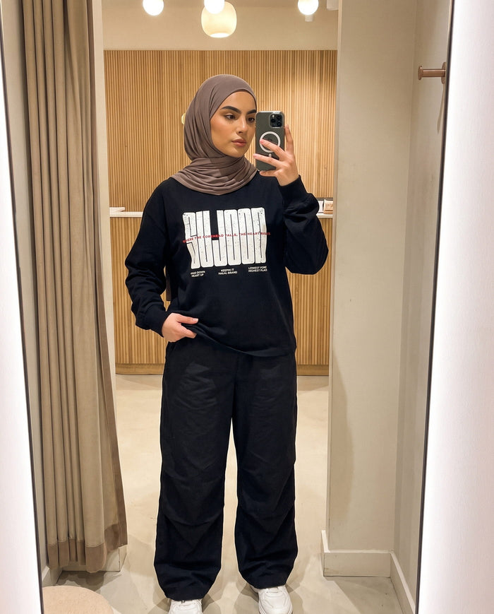 Sujood for the Heart black long sleeve in a fitting-room mirror