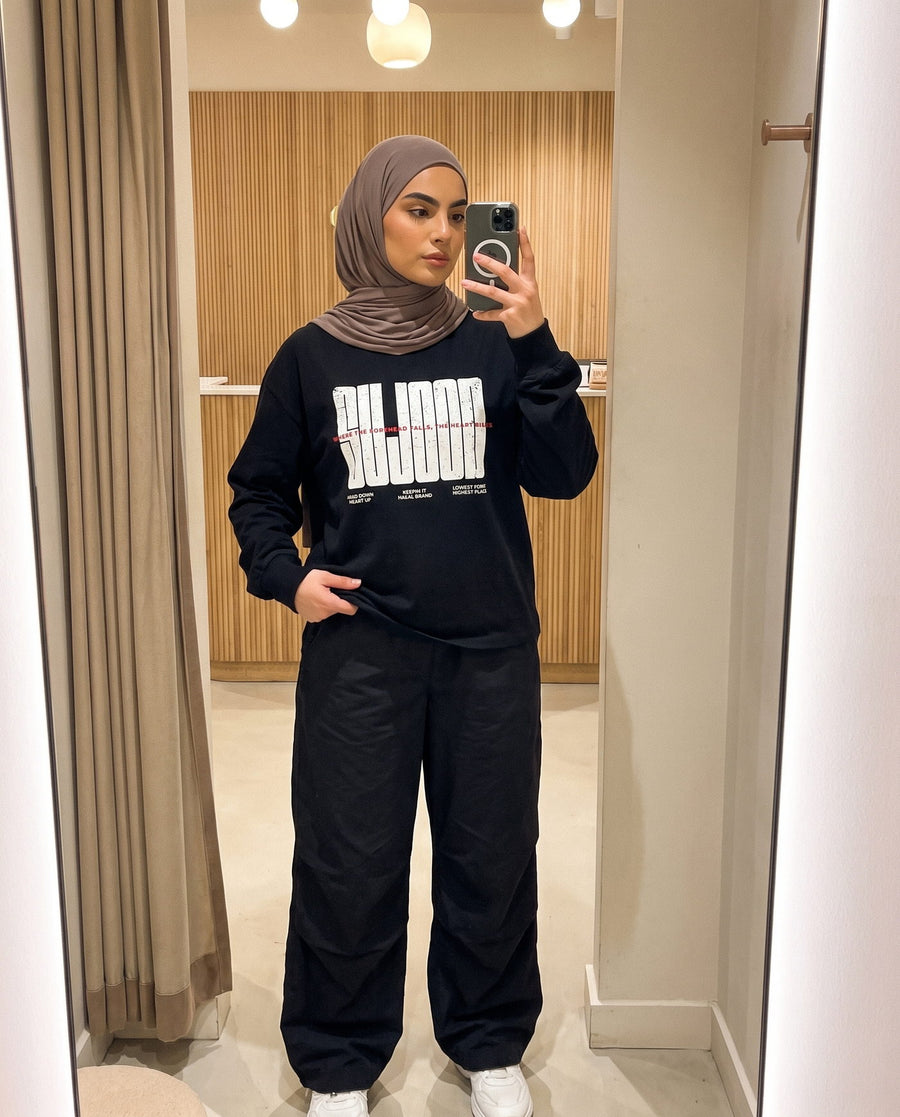 Sujood for the Heart black long sleeve in a fitting-room mirror