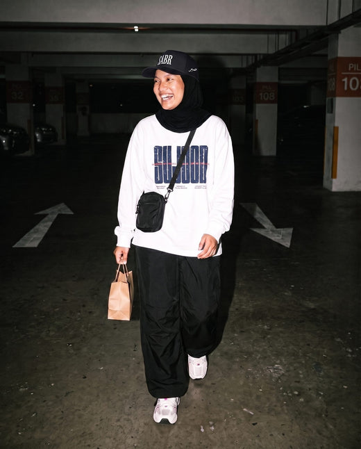 Sujood for the Heart white long sleeve in a parking garage