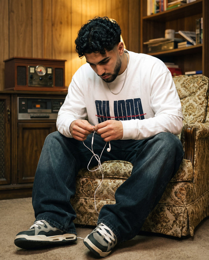 Sujood for the Heart white long sleeve in a wood-panelled room