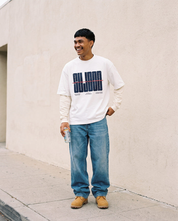 Sujood for the Heart white long sleeve against a plain wall