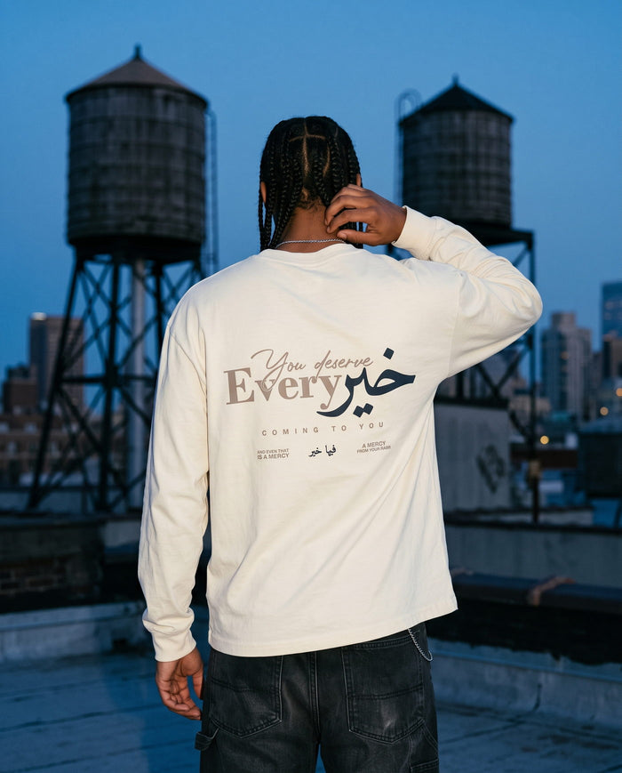 You Deserve Every Khayr bone long sleeve back print on a rooftop at blue hour