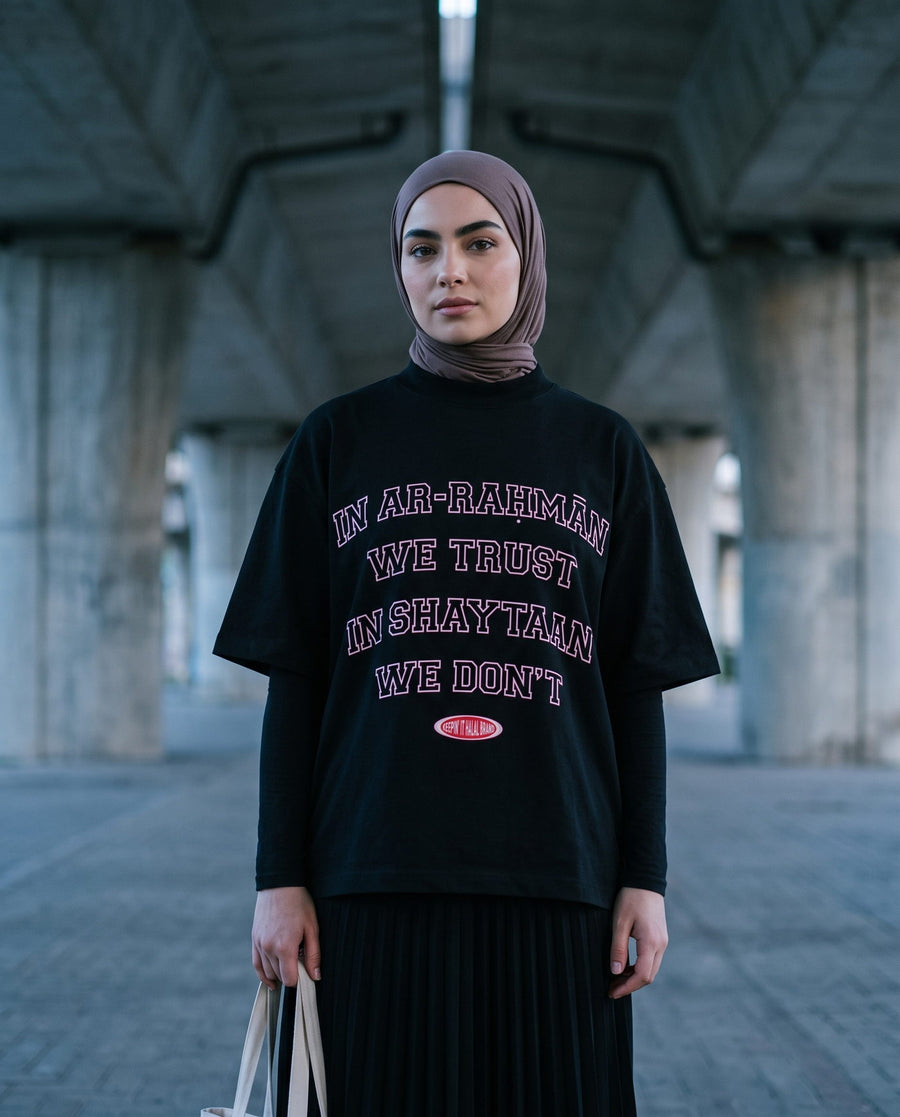 In Ar-Rahman We Trust black boxy tee beneath an overpass at blue dusk