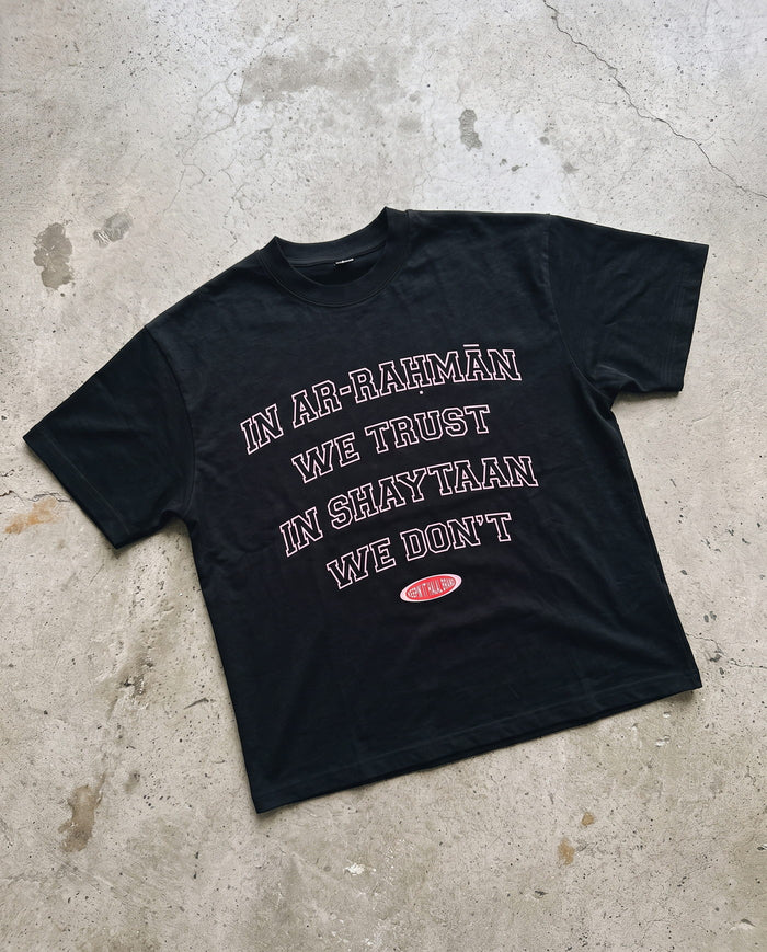 In Ar-Rahman We Trust black boxy tee laid flat on concrete
