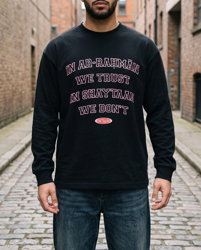 In Ar-Rahman We Trust black long sleeve walking a cobbled alley