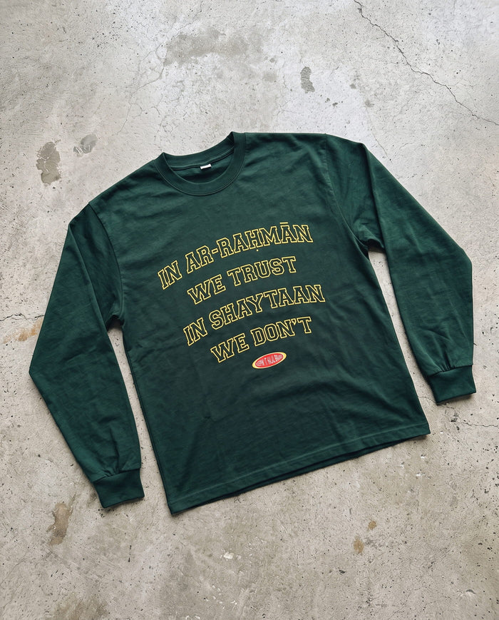 In Ar-Rahman We Trust hunter green long sleeve laid flat on concrete