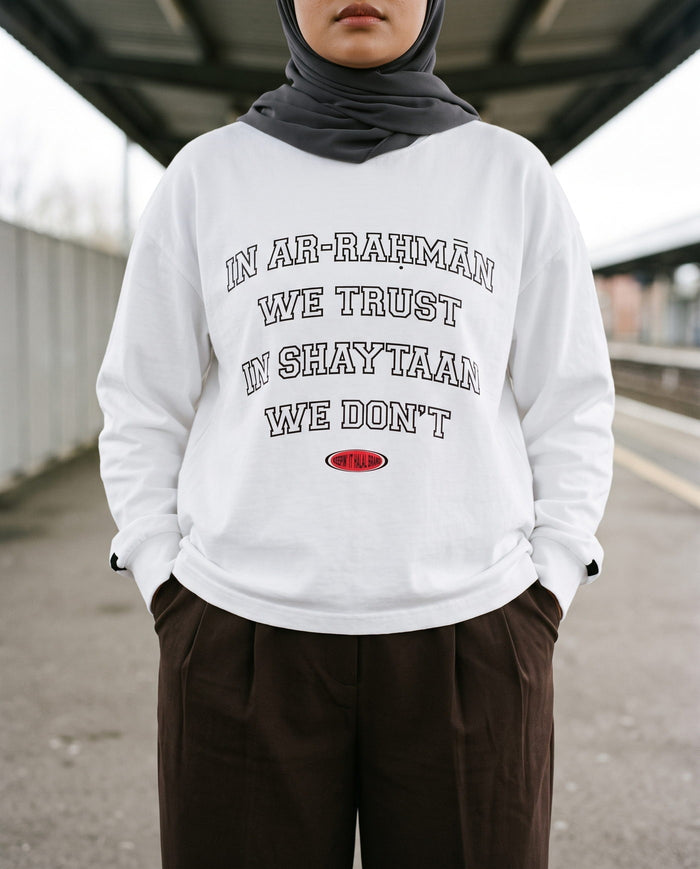 In Ar-Rahman We Trust white long sleeve on a railway platform