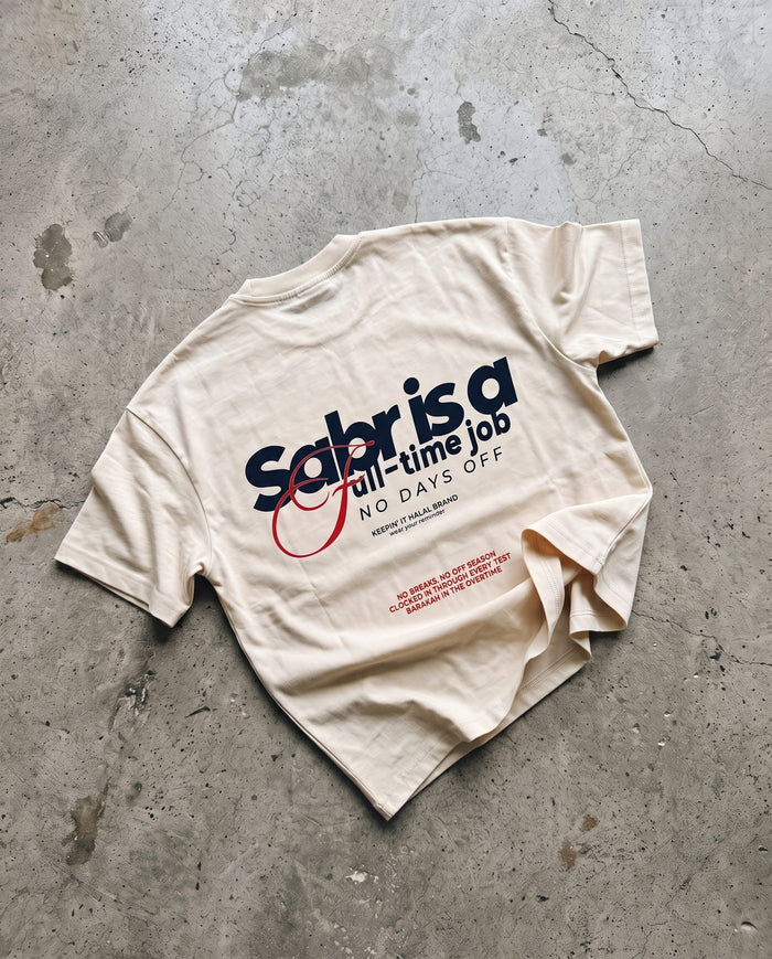Full-Time Sabr natural boxy tee laid back-side-up on concrete