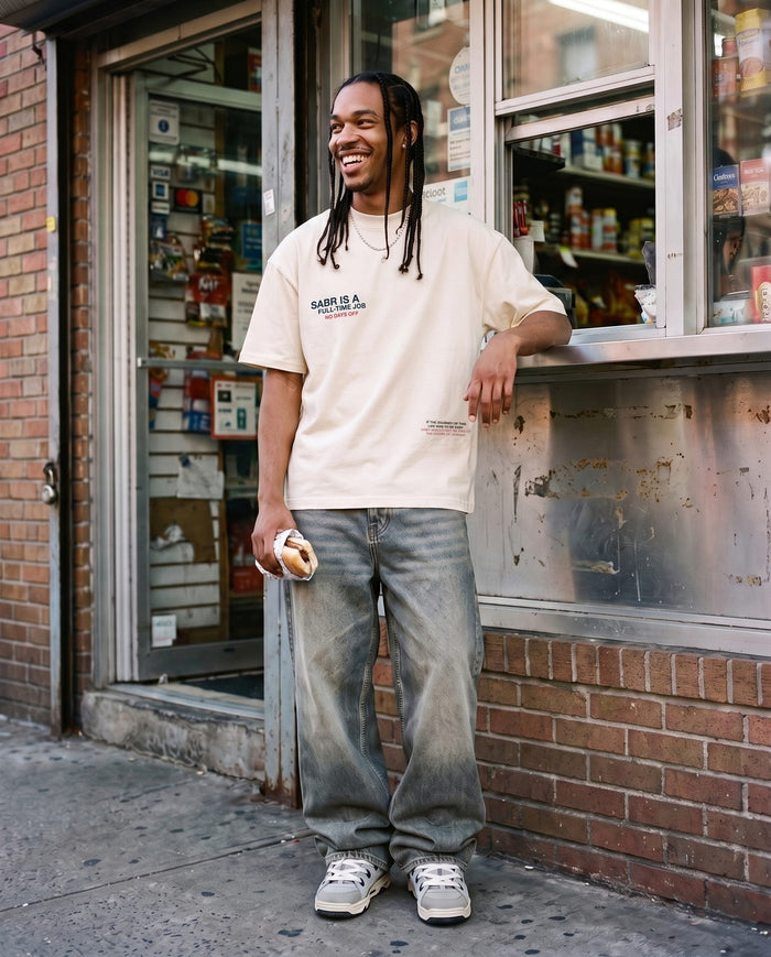 Full-Time Sabr natural boxy tee, front chest hit, outside a corner shop