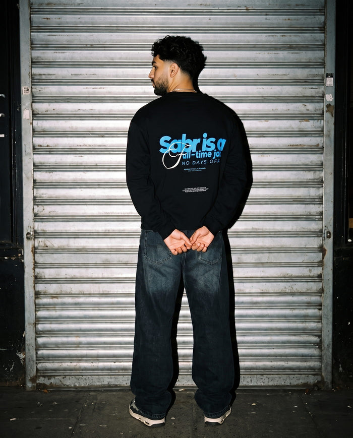 Full-Time Sabr black long sleeve back print in front of a shutter