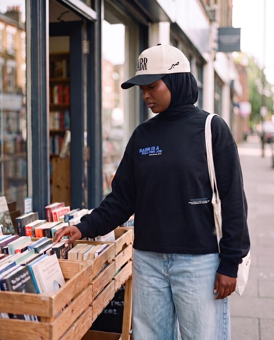 Full-Time Sabr black long sleeve, small front chest hit, at a bookshop stall